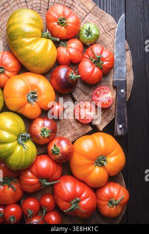 Helle Erbstücke, die auf rundem Schneidebrett angeordnet sind. Rustikales Küchendesign, vegetarische gesunde Zutaten Stockfoto
