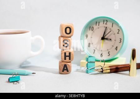 OSHA - Wort aus Holzwürfeln, Buchstaben auf weißem Hintergrund, Kopierraum für Text Stockfoto