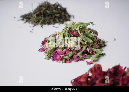 Getrocknete Kräutertee-Mischung mit Rosenblüten, Kamillenblüten und Hibiskus auf weißem Hintergrund Stockfoto