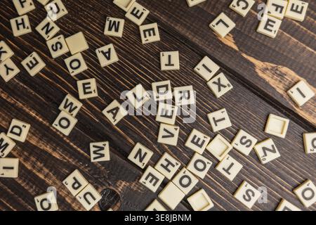 Lemberg Ukraine 02.26.26 Spieler versammeln sich am Nationalfeiertag um einen Holztisch. Die Buchstabensteine werden ausgebreitet, während sie sich auf ein lustiges Spiel vorbereiten. Stockfoto