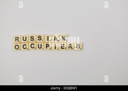Lemberg Ukraine 02.26.26 Spieler verwenden Scrabble-Steine, um Wörter auf einer glatten Oberfläche für den nationalen Scrabble-Tag zu erstellen. Die Buchstaben bilden die Wörter RUSSISCH und Stockfoto