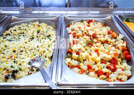 Selbstbedienungs-Buffetstation im Restaurant, Hotel oder Café nach dem shvedskiy stol-Prinzip organisiert. Rostfreie Scheuerschalen enthalten gebratenen Reis Stockfoto