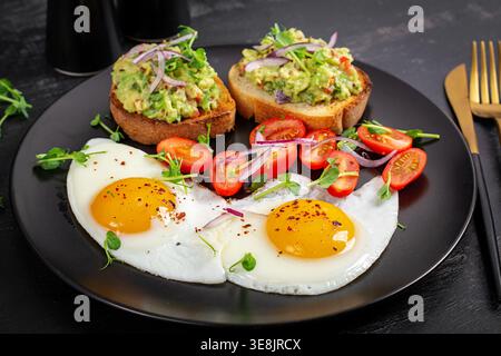 Proteinreicher Brunch mit sonnigen Eiern und Avocado-Toast Stockfoto