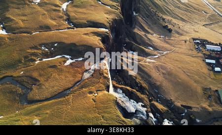 Flusslauf, der durch die Hügel islands fließt, natürlicher foss, ein Sidu-Wasserfall in isländischer Landschaft. Spektakuläre Kaskade, die von skandinavischen Klippen abfällt. Zeitlupe. Drohnenaufnahme. Stockfoto