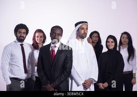 Vielseitiges multikulturelles Geschäftsteam mit emiratischen Führungskräften und professionellen Kollegen, die selbstbewusst in Unternehmensphilosophie posieren Stockfoto