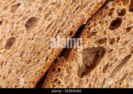 Vollbild-Makroaufnahme von zwei Scheiben helles Roggenbrot mit poröser Krume und diagonaler Zusammensetzung. Detaillierte Innenausstattung mit unregelmäßigen Lufteinschlüssen. Stockfoto