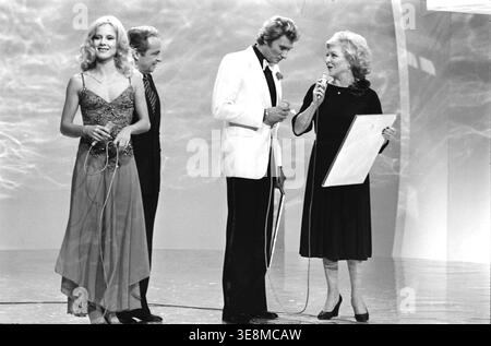 Die französische Sängerin Sylvie Vartan am Set der Fernsehsendung „Système 2“, präsentiert von Guy Lux, erhielt ein Fauteuil d’Or für ihren Auftritt im Palais des Congrès in Paris. Auf der rechten Seite erhält Johnny Hallyday eine Auszeichnung von Line Renaud. November 1975 Stockfoto
