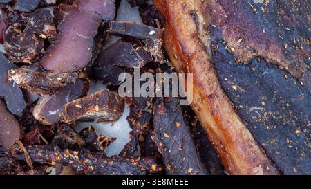 Nahaufnahme der Vollformatstruktur traditioneller südafrikanischer Biltong. Satte dunkle Töne und detaillierte Oberfläche machen es ideal als Lebensmittelhintergrund oder Textur f Stockfoto