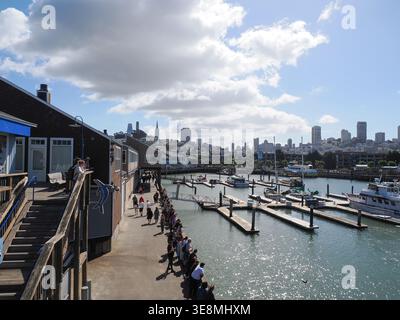 San Francisco, Vereinigte Staaten - 3. Oktober 2025 - Touristen stehen am Meer am Sea Lion Center am Pier 39 mit Blick auf den Yachthafen Stockfoto