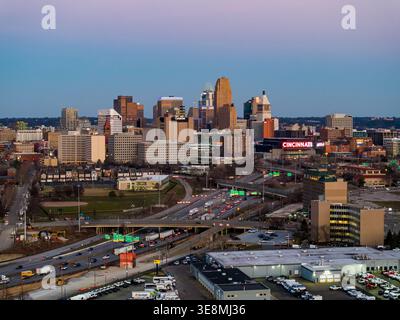 Blick aus der Vogelperspektive auf die pulsierende Skyline von Cincinnati, wo der unverwechselbare Great American Tower in der Nähe des lebhaften Paul Brown Stadions den Horizont durchdringt. Stockfoto