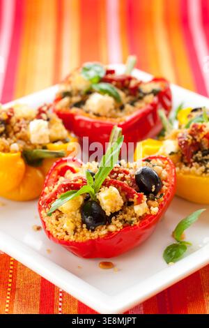 Gefüllte Paprika mit Couscous, getrockneten Tomaten, Feta, Oliven und Basilikum Stockfoto