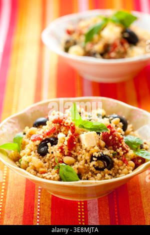 mediterraner Couscous-Salat mit getrockneten Tomaten, Feta, Oliven und Basilikum Stockfoto