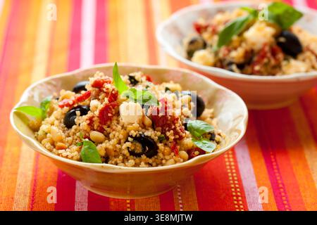 mediterraner Couscous-Salat mit getrockneten Tomaten, Feta, Oliven und Basilikum Stockfoto