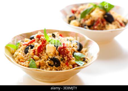 mediterraner Couscous-Salat mit getrockneten Tomaten, Feta, Oliven und Basilikum Stockfoto
