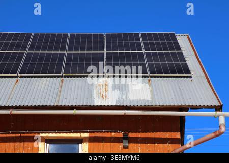 Ländliches Haus mit Photovoltaik-Panels in Polen nachgerüstet. Sonnenkollektoren auf dem Dach eines Berghauses. Stockfoto