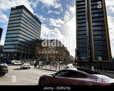 Manchester, Großbritannien - 22. Februar 2026: Städtischer Knotenpunkt in Manchester, Großbritannien, mit gemischter moderner und historischer Architektur, Verkehr, Radfahrern und Dramatikern Stockfoto