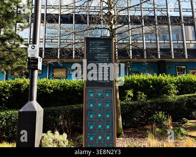 Manchester, Großbritannien - 22. Februar 2026: Wegweiser und Richtungsverzeichnis in Manchester, Großbritannien neben modernen Büros und Landschaftsbepflanzungen. Stockfoto