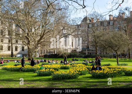 Menschen, die sich an einem sonnigen Frühlingstag im St. Jamess Park in London entspannen Stockfoto