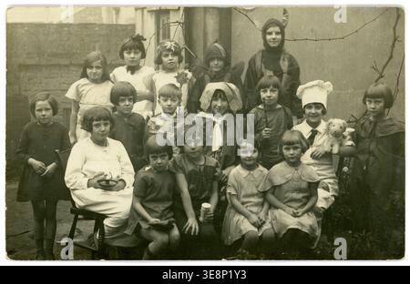 Ursprüngliche Postkarte aus der Zeit der 1920er/1930er Jahre, Kinder Mottoparty, Kinder Mottoparty, Kinder aus den 1930er Jahren, die Spaß haben, Kinder aus den 1900er Jahren. Freizeit der 1900er Jahre. Gosport, Hampshire, England, Großbritannien. Stockfoto