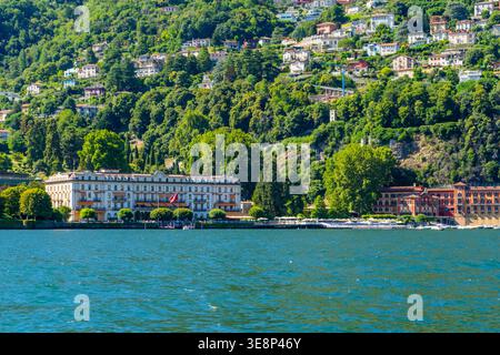 Villa d'Este am Ufer des Comer Sees in Cernobbio, Italien Naturwasserresort. Mehrfarbige Häuser auf grünen Hügeln. Italienische Reise grüne Bergdorf Villa Haus im Freien. Italien, Como - 17. Juli 2025 Stockfoto