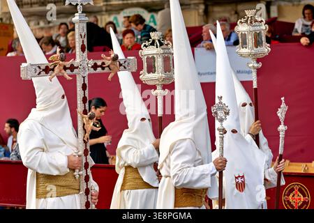 Menschen in weißen Gewändern und spitzen Kapuzen nehmen an Osterprozessionen in Malaga, Spanien, teil. Diese Veranstaltung ist Teil der Feierlichkeiten der Karwoche. Stockfoto