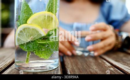 Ein Glas Süßwasser mit Minze und Zitrone steht auf Einem Kaffeetisch Stockfoto