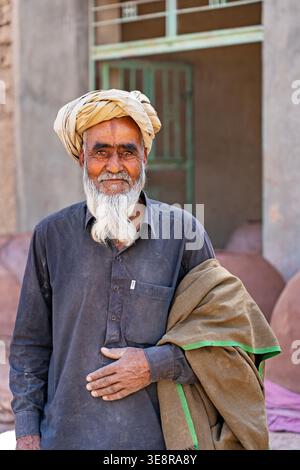 Porträt eines lokalen Afghanen, der einen traditionellen Turban trägt, in einem abgelegenen Dorf in der Provinz Ghor, Zentralafghanistan Stockfoto