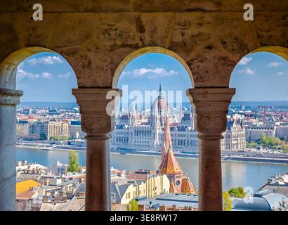 Budapester Parlament durch den Fishermans Bastion Bogen, ikonisches ungarisches Wahrzeichen, atemberaubende Aussicht, historische Architektur und Reiseziel Szene Stockfoto