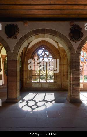 Gotisches Sandsteinbogenfenster und dramatisches Sonnenlicht im mittelalterlichen Klosterhof im Kloster Basel, Basel Schweiz Stockfoto