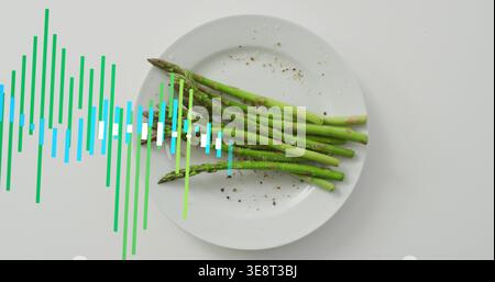 Es erscheint eine Wellenform-Überlagerung, die Spargelbündel auf weißer Platte zeigt, Tischplatte mit Pfeffer und Salz Stockfoto