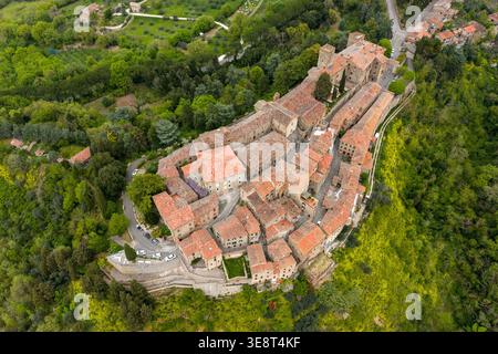 Blick aus der Vogelperspektive auf das historische Dorf auf einem Hügel mit traditionellen Steinhäusern und Terrakottadächern, umgeben von üppigen grünen Wäldern in Parrano, Umbri Stockfoto