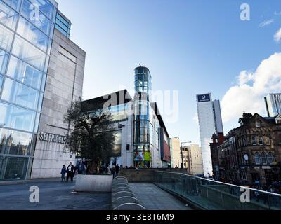 Manchester, Großbritannien - 28. Februar 2026: Modernes Selfridges-Gebäude und umliegende Stadtstraßen in Manchester, Großbritannien, mit Fußgängern und Einzelhandelsaktivitäten. Stockfoto
