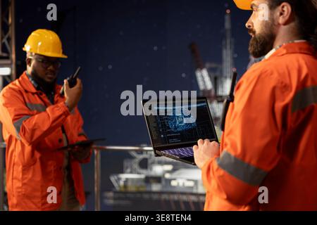 Experten für die Offshore-Plattform, die KI-Modelle für neuronale Netzwerke verwenden, um den Wartungsbedarf der Ausrüstung vorherzusagen. Teamkollegen am Bohrgerät analysieren maschinelle Lerndaten, um mechanische Ausfälle zu vermeiden Stockfoto