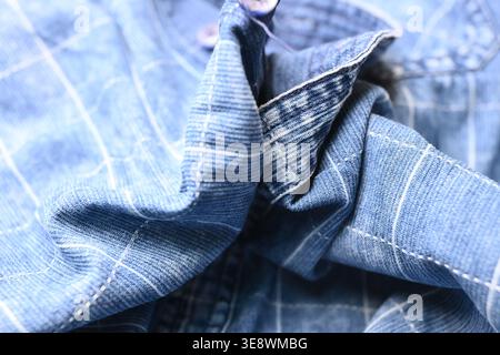 Blaues Shirt mit Rasterlinien – Makroaufnahme aus gezacktem Stoff mit horizontalem und vertikalem Muster und weichem, unscharfem Hintergrund Stockfoto