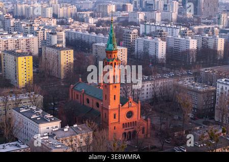 Blick aus der Vogelperspektive auf die historische Augustinerkirche aus rotem Backstein mit ihrem hohen grünen Turm, umgeben von Wohnblocks und dem städtischen Skylin Stockfoto