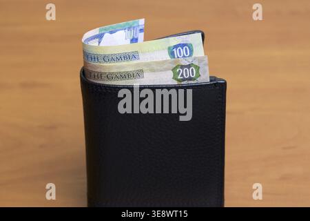 Gambische Geld - Dalasi in der schwarzen Brieftasche Stockfoto