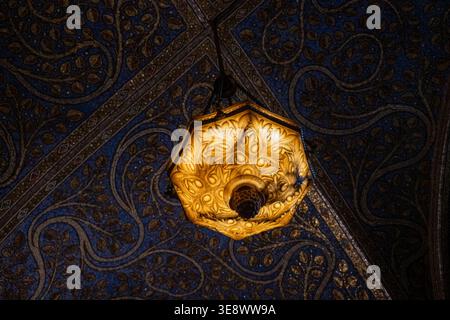 Kunstvolle Hängeleuchte, beleuchtet auf blau-goldenen Mosaikgewölbe im Aachener Dom in Aachen, Nordrhein-Westfalen, Deutschland. Stockfoto
