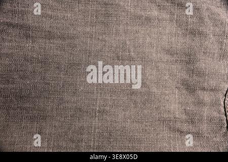 Graues Denim-Hemdgewebe Close-up – Jeans-Textur mit gefalteter Jeans-Struktur und weichem, unscharfem Hintergrund Stockfoto