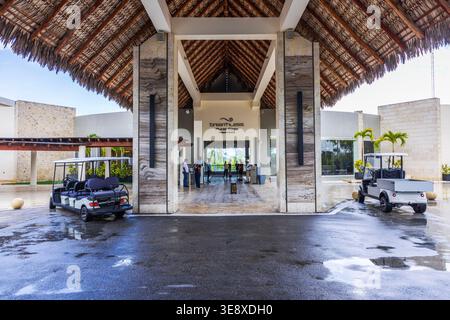 Wunderschöner Blick auf den atemlosen Eingang des Punta Cana Resorts mit Gästen in der Nähe der Lobby und Service Carts in tropischer Umgebung. Dominikanische Republik. Punta Cana. Stockfoto