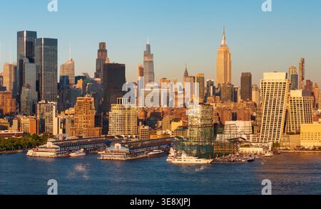 Panoramablick auf die Skyline von Manhattan bei Sonnenuntergang mit Wolkenkratzern in Midtown, Hudson River Uferpromenade und Chelsea Piers. New York City, USA Stockfoto