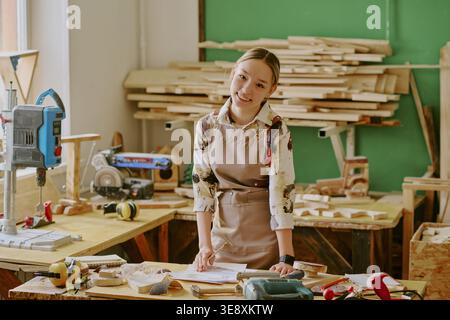 Porträt einer Teenager-Frau, die das Holzarbeitsprojekt in der Werkstatt plant Stockfoto