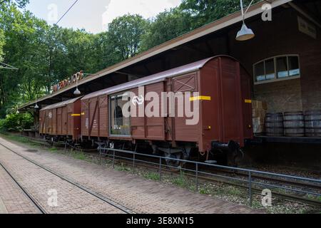 Arnhem, Niederlande - 27. Mai 23: Reihe von Oldtimer-Güterwagen auf Gleisen neben einem Lagerbahnsteig im Niederländischen Freilichtmuseum, Arnhem, Gelde Stockfoto