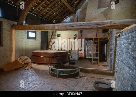 Arnhem, Niederlande - 27. Mai 23: Rustikales Bauernhaus mit Holzwanne, Ziegelboden und Werkzeugen im Niederländischen Freilichtmuseum in Arnh Stockfoto