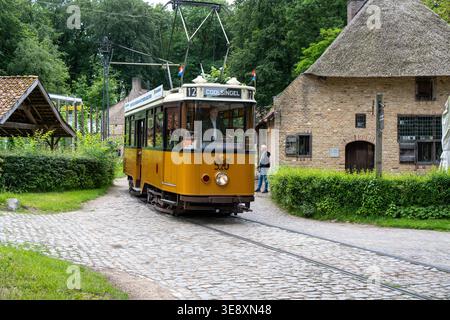 Arnhem, Niederlande - 27. Mai 23: Alte elektrische Straßenbahn fährt durch eine rekonstruierte Dorfstraße im Niederländischen Freilichtmuseum in Arnhem, ne Stockfoto