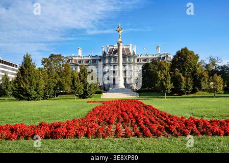 Leuchtend rote Blumen wachsen an einem klaren, sonnigen Tag vor dem Eisenhower Executive Office Building in Washington D.C. Stockfoto