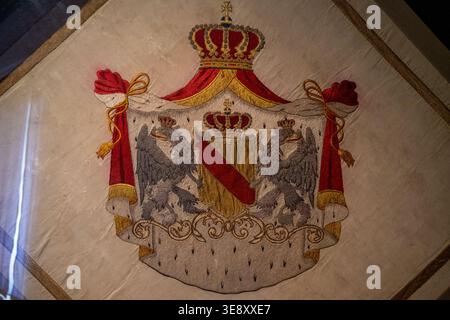 Karlsruhe, Deutschland - 4. Mai 24: Nahaufnahme eines gestickten Wappentextils mit Krone und Adler im Karlsruher Schlossmuseum Stockfoto