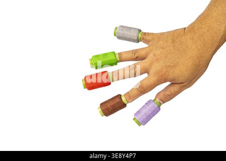 Detaillierte Nahaufnahme einer Hand mit fünf leuchtenden Garnspulen mit Stickerei und markanten neongrünen Kunststoffkappen. Die Spulen sind grau, Limette g Stockfoto