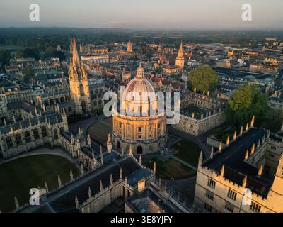 Luftaufnahme der Radcliffe Camera und des All Souls College bei Sonnenuntergang, mit Türmen der Oxford University und der Skyline der Stadt dahinter in Oxfordshire, England Stockfoto