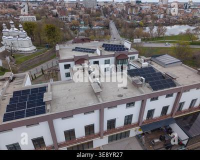 Blick aus der Vogelperspektive auf moderne Wohnreihenhäuser mit Solarpaneelen auf Dächern. Die Szene repräsentiert nachhaltiges urbanes Wohnen, saubere Energie Stockfoto
