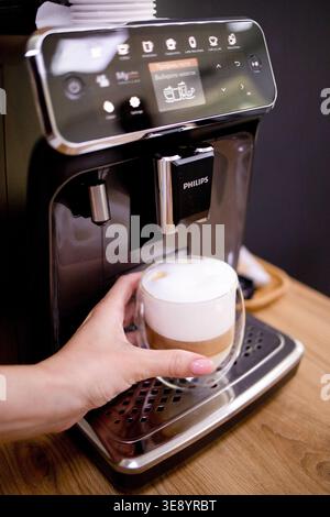 Junge Frau, die Kaffee mit einer Kaffeemaschine zuhause oder in einem Café zubereitete. Lifestyle, morgendliche Routine, Frühstück, Getränkezubereitung und gemütliches Zuhause Stockfoto